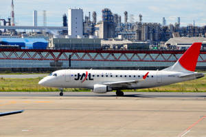 J-AIR飛機在工業區和紅色橋樑附近的跑道上。