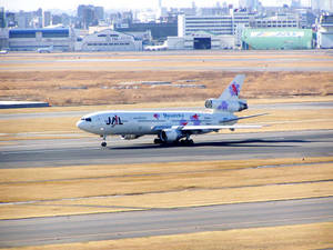 JAL Reso'cha波音767在機庫附近的機場跑道上滑行。