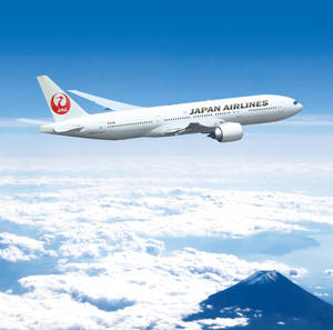 日本航空飛機飛越雲層，富士山清晰可見。