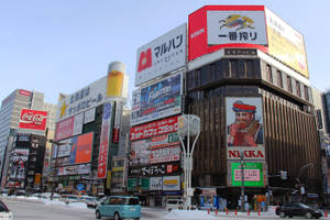 日本積雪的城市街道，高聳的建築物上掛滿了明亮的霓虹招牌和廣告。 — 唐人街 GIF 壁紙