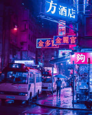 撐傘的人在雨夜霓虹燈照亮的城市街道上行走。 — 日本 壁紙