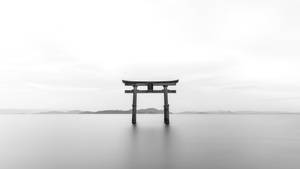 傳統日本鳥居在水中，遠方有山丘。