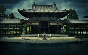 古老日本寺廟在黑暗的暴風雲下，有碎石庭院和靜止的水面。