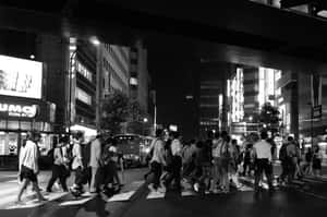 夜晚人群在霓虹燈下穿越繁忙的東京街道。