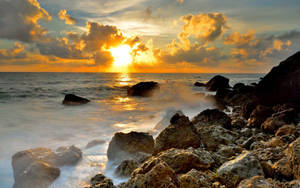 夕陽映照海洋，海浪拍打岩石海岸