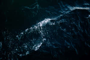 深色海浪在深藍色海水中翻騰著白色泡沫。
