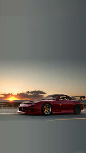 紅色Mazda RX-7跑車停泊在日落時分的沙漠道路上。