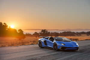藍色林寶堅尼Aventador在沙漠公路上，背景是日出和山脈。 — 汽車 壁紙