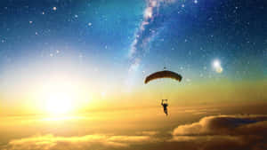 跳傘運動員在日落時漂浮在雲層之上，星星和銀河可見。