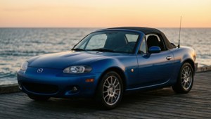 藍色萬事得MX-5開篷車停泊在日落時分木製碼頭海景