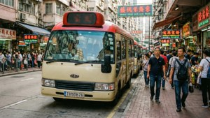 米色小巴在繁忙的香港街道上，有行人和霓虹招牌。
