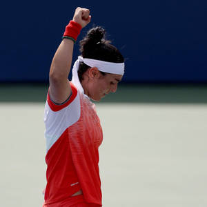 女網球運動員在球場上高舉拳頭慶祝勝利。 — 網球 壁紙