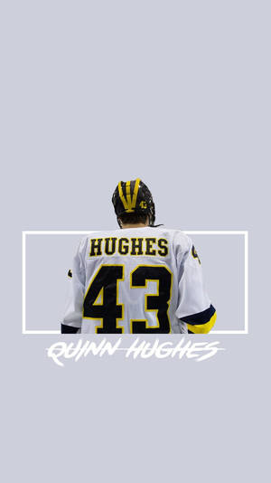 冰球運動員 Quinn Hughes 身穿白色球衣，號碼 43，背對鏡頭。