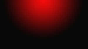 一個發光的紅色圓形漸變，逐漸融入黑色。 — AMOLED 壁紙