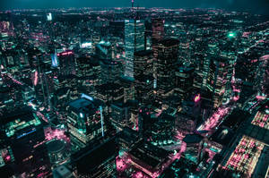充滿活力的城市夜景鳥瞰圖，有閃爍的摩天大樓和霓虹燈。