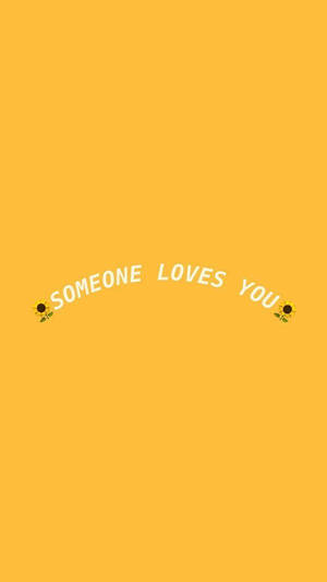 黃色背景上寫有白色文字「someone loves you」，兩側有向日葵表情符號。 — 黃色 壁紙
