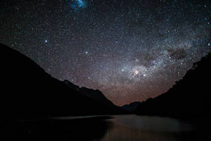 銀河系在夜晚照耀著山間湖泊
