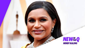 Mindy Kaling 在頒獎典禮上穿著黃色連衣裙，佩戴鑽石珠寶微笑。