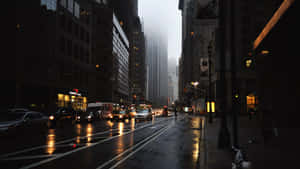 黃昏時分雨中的城市街道，濕漉漉的路面，霧中的摩天大樓。