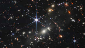 深空中密集的星系和恆星場，帶有明亮的星爆效果。 — 星星 壁紙