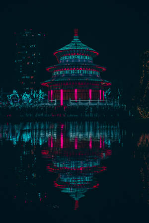 夜間水中倒映的霓虹寶塔，背後城市燈光。