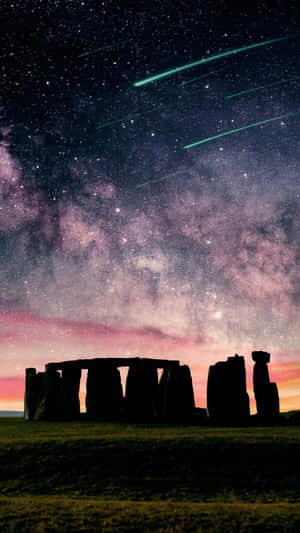 夜晚的巨石陣，天空佈滿星星和綠色流星軌跡。