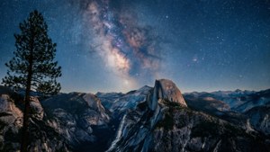 夜晚半圓頂山下的銀河，前景有松樹