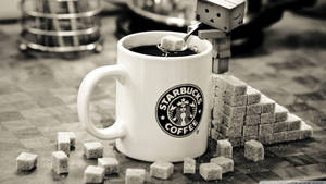 一個機械人正在為被方糖包圍的Starbucks咖啡杯加糖。 — 星巴克 壁紙