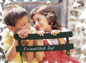 兩個孩子在帶有「Friendship Day」文字和星星裝飾的長椅上微笑。