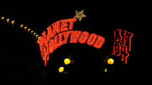 Planet Hollywood 霓虹招牌在夜晚與星星和溫暖燈光一同閃耀。 — 荷里活 GIF 壁紙