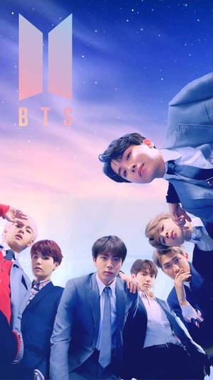 七位穿著正式服裝的K-pop偶像在星空下與BTS標誌一起擺姿勢。