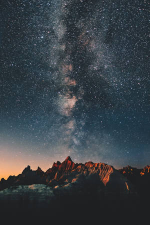夜間崎嶇山脈上空的銀河系