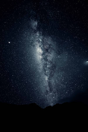 銀河系在星空下照耀著山巒輪廓。