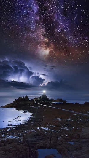燈塔在岩石海岸上發光，星空下