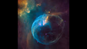 一個充滿活力的藍色泡泡星雲，在深空中帶有橙色和藍綠色的雲。 — 銀河 壁紙