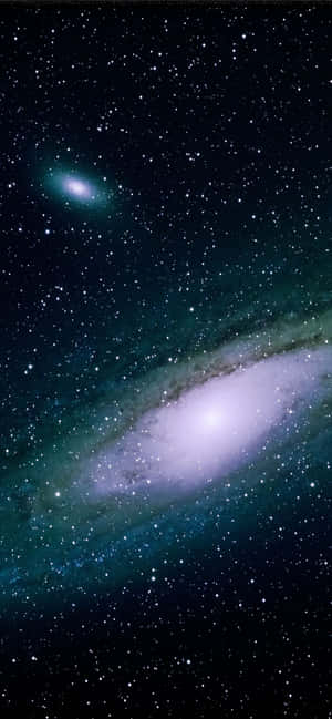 一個螺旋星系，其紫色和藍綠色的旋臂在無數星星中閃耀。 — 太空 壁紙