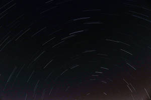 星軌在長時間曝光的照片中彎曲穿過黑暗的夜空。