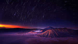 星軌與暮色天空下的火山景觀 — 夜空 壁紙