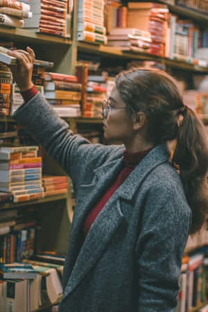 女性在舒適的書店中瀏覽書籍，燈光溫暖。
