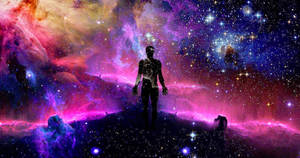 一個人站在宇宙山丘上，下方是色彩繽紛的星雲。