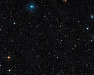 繁星點點的夜空，明亮的藍色和橙色星星散落在黑色虛空中。