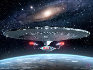 星艦 NCC 1701D 環繞著一顆藍色行星運行，背景是螺旋星系。