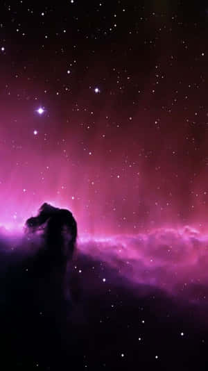 一個宇宙柱輪廓在充滿星星的發光紫色星雲前。