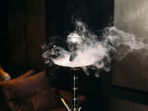 銀色水煙管在昏暗休息室中與棕色皮革沙發一起冒出旋轉煙霧。