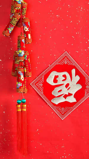 中國新年裝飾，帶有紅色流蘇和紅色背景上的「福」字。 — 聖誕節 iPhone 壁紙