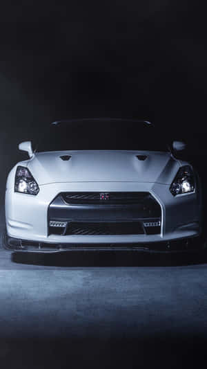 白色日產GT-R跑車在黑暗的攝影棚環境中照亮。