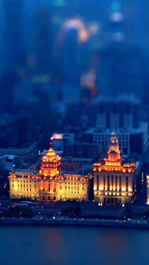 使用移軸效果的夜間城市景觀，包含照明建築和水面倒影。