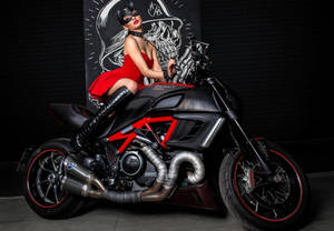 身穿紅色連衣裙和貓面具的女性在Ducati摩托車上擺姿勢，背後有骷髏壁畫。 — 機車 壁紙