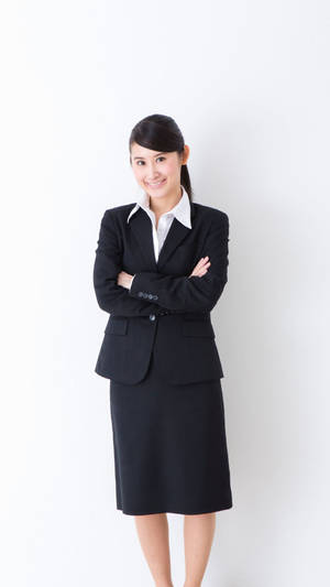 微笑的商務女性穿著黑色西裝，在白色背景前交叉雙臂站立。 — 黑色動態圖 壁紙