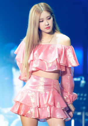 K-pop 表演者穿著粉紅色荷葉邊服裝在藍色燈光舞台上 — 熱粉紅美學 壁紙